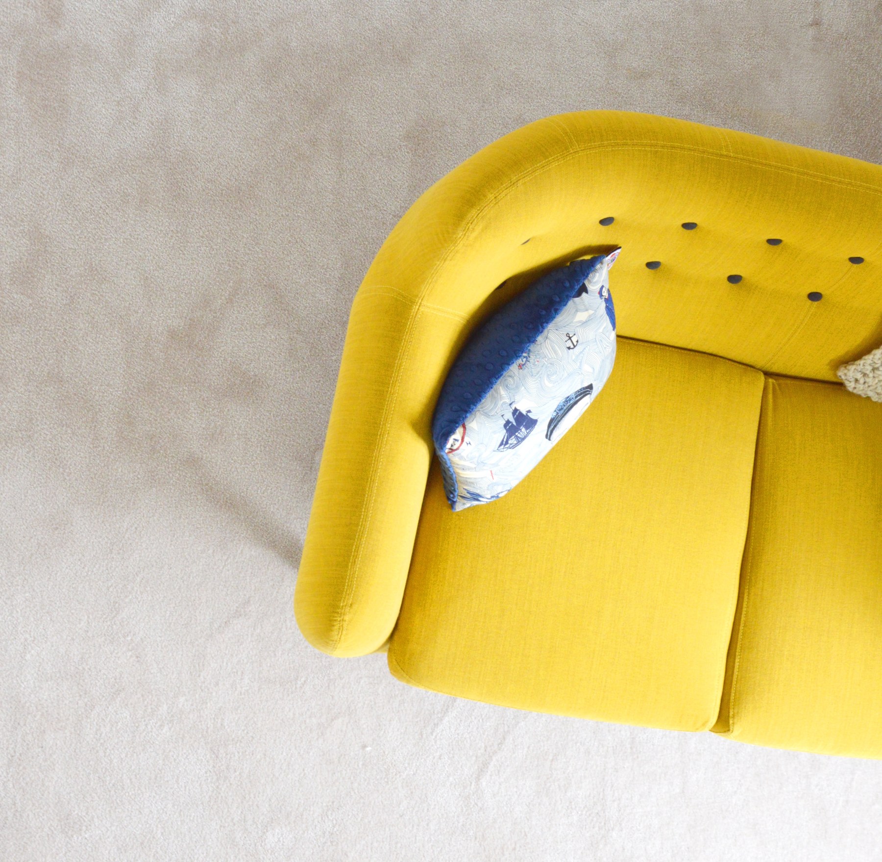 Yellow upholstered sofa with a decorative cushion Yellow upholstered sofa with a decorative cushion