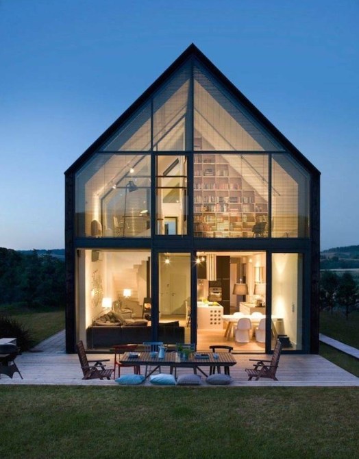 Two-storey house with a glazed gable facade at dusk Two-storey house with a glazed gable facade at dusk