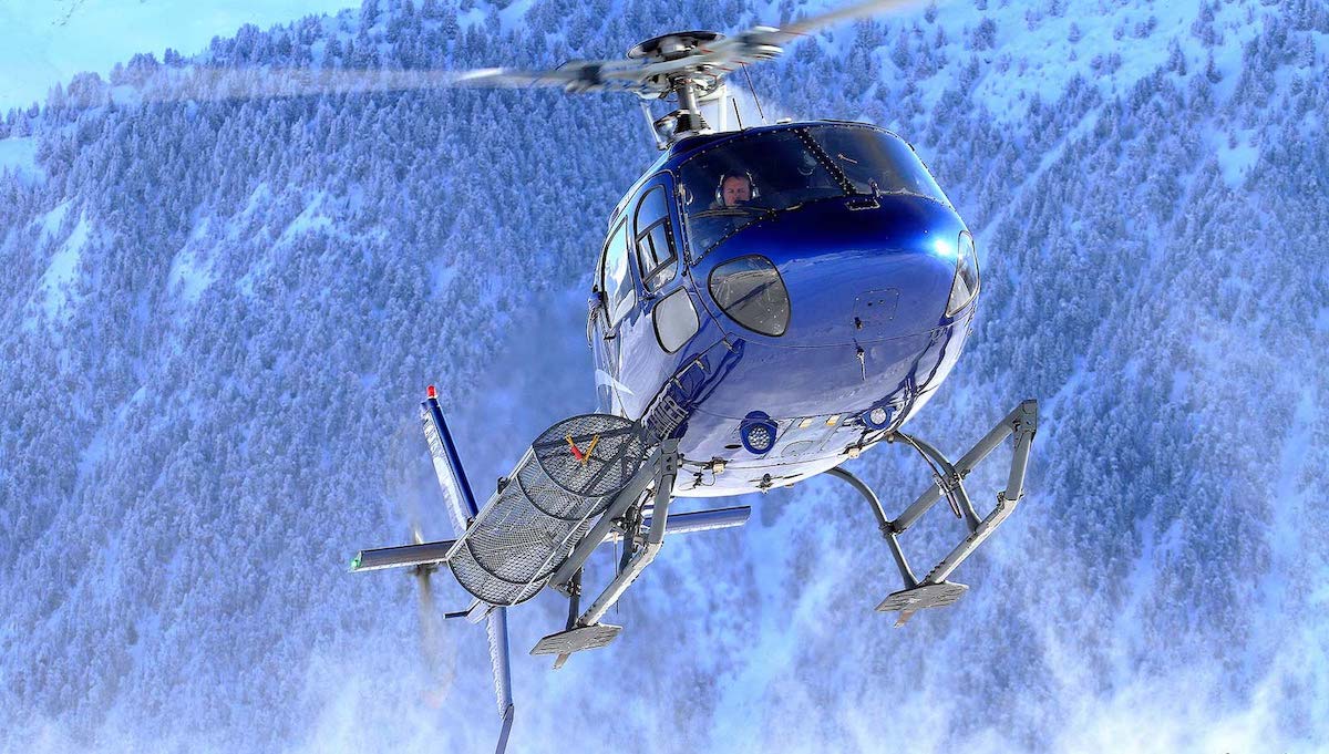 Blue AS350 helicopter on a landing pad
