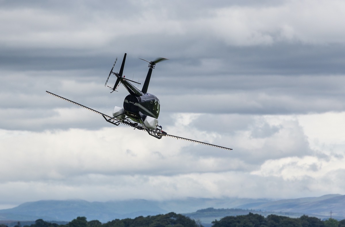Helicopter in flight against a cloudy sky and hills Helicopter in flight against a cloudy sky and hills