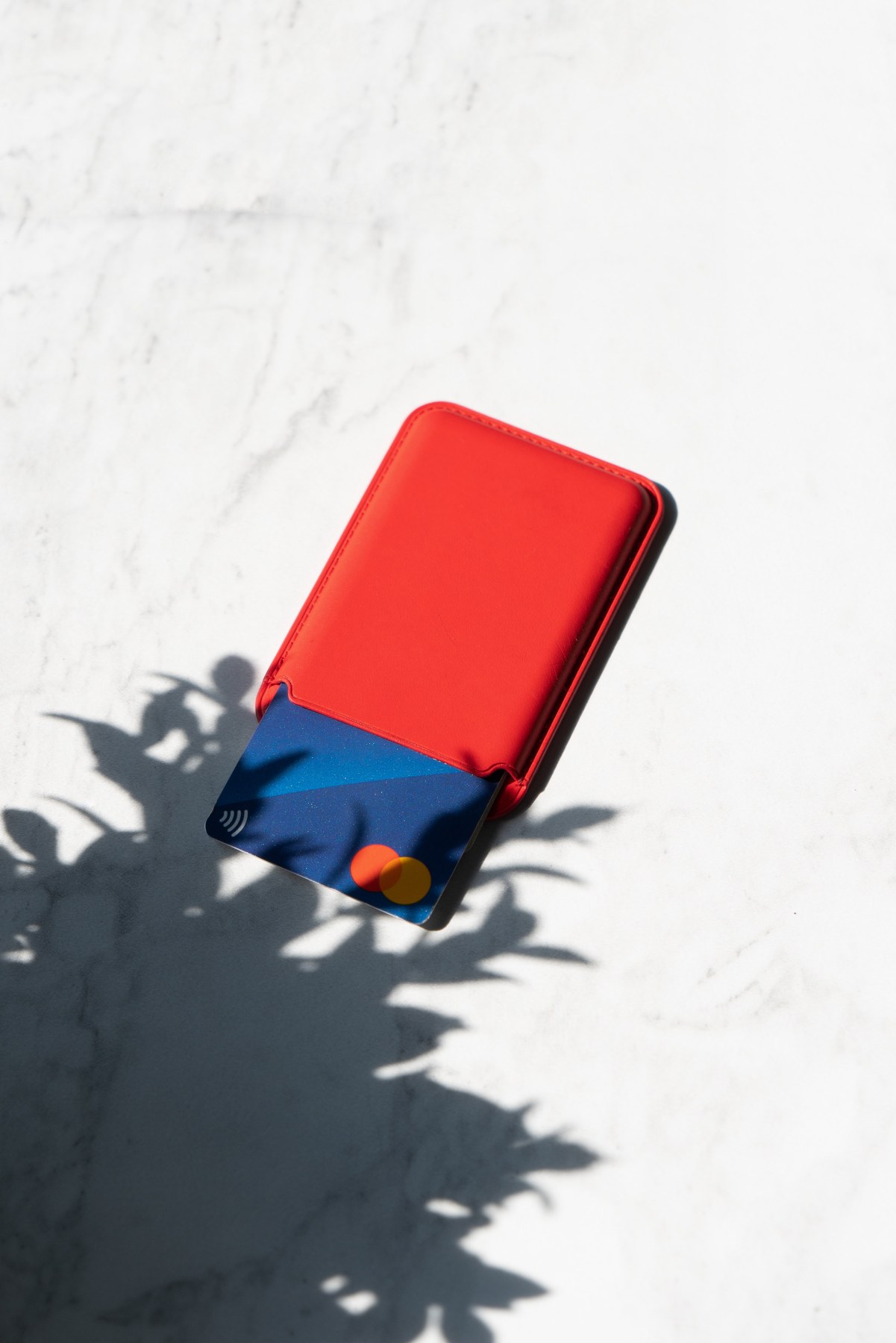 Red wallet and bank card on a light surface Red wallet and bank card on a light surface